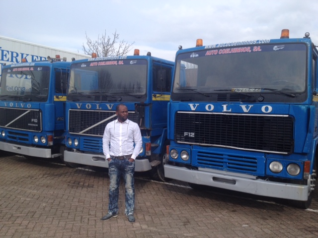 trucksafleveren Een tevreden klant in een haven in West-Afrika na ontvangst van een aantal trucks voor hem opgezocht en verscheept